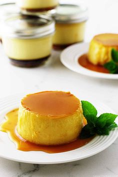 two white plates topped with desserts covered in caramel sauce and garnished with mint