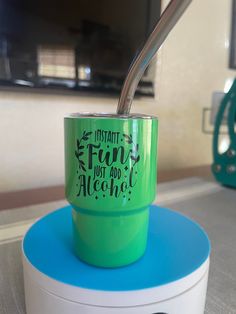 a green cup with a straw sticking out of it