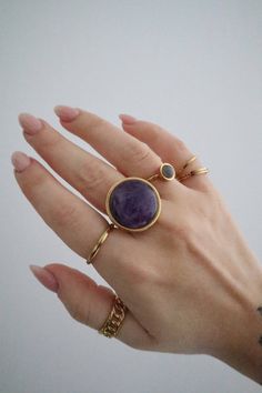 A large statement crystal ring made of gold stainless steel with an adjustable band.  The ring features a round polished amethyst crystal of 2cm in diameter. Gold Jewelry With Large Round Stone, Minimalist Gold Amethyst Ring, Gold Amethyst Ring With Large Stone As Gift, Modern Adjustable Crystal Ring, Modern Adjustable Round Crystal Ring, Gold Amethyst Ring With Natural Stones As Gift, Minimalist Metal Crystal Ring For Gift, Modern Purple Metal Jewelry, Modern Adjustable Jewelry With Large Stone