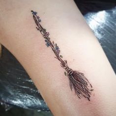 a small arrow tattoo on the arm