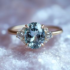 a blue and white diamond ring sitting on top of snow