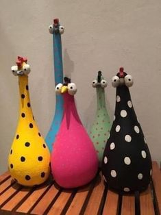 four colorful vases sitting on top of a wooden table