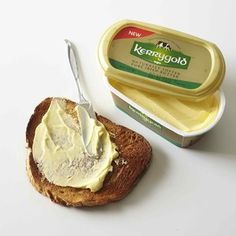 a piece of bread with butter on it next to a container of mayonnaise