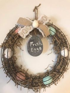 a wreath with an egg on it and a chalkboard saying fresh eggs