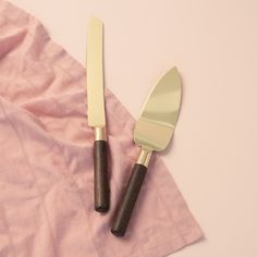 two knives and a fork on a pink cloth