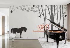 a piano in front of a wall with a horse and tree decal on it