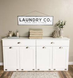 a white cabinet with some towels on top and a sign above it that says laundry co