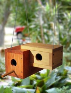 a wooden birdhouse hanging from a tree