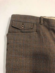 "Vintage Men's 80's Brown, Plaid, Straight Leg, Pants (W40) 1097 These Men's Pants come in a brown polyester/viscose blend and has a plaid print in blue and orange with a zipper fly, five pockets, and straight leg fit with a pressed seam. The pants are heavy weight and do not stretch and are not lined. 65% Polyester 35% Viscose *These pants are in like new condition. *If shipped within the US, they will go Priority Mail for a quick delivery! Size: (W40 x L32) Waist: 40\" Hips: 44\" Inseam: 33\" Brown Straight Leg Pants With Welt Pockets, Tailored Brown Bottoms With Tapered Leg, Brown Tailored Tapered Leg Bottoms, Brown Wool Straight Pants, Classic Brown Bottoms With Hip Pockets, Brown Wool Pants With Belt Loops, Fitted Brown Bottoms With Welt Pockets, Brown Trousers With Hip Pockets, Brown Wool Bottoms With Belt Loops