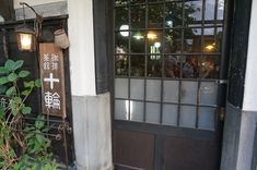 an entrance to a restaurant with chinese writing on the door and window panes above it