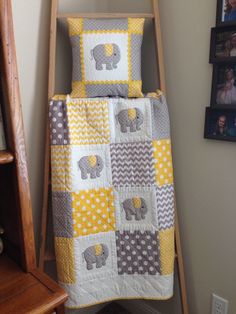 a baby bed with an elephant quilt and matching pillow shampoo on the bottom bunk