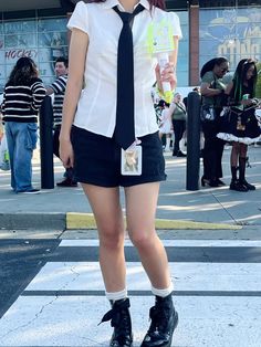 a woman in short shorts and tie standing on the street