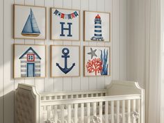 a baby's room with nautical themed artwork on the wall and a crib