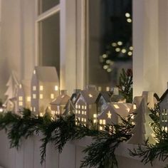 a window sill decorated with christmas lights and small houses