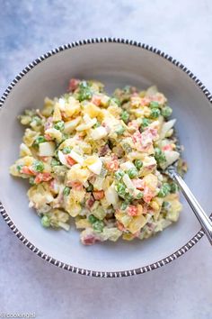 a white bowl filled with pasta and peas