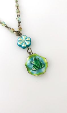 This sweet necklace is made using a vintage enamel frog on lily pad sterling silver pendant, a glass flower bead, and a crystal beaded necklace.  The necklace is 16 inches long, with a 1 1/2 inch drop.It is handmade and a one of a kind! Whimsical Green Nickel-free Jewelry, Whimsical Blue Jewelry With Flower Charm, Adjustable Green Enamel Jewelry, Vintage Green Jewelry With Unique Variations, Vintage Turquoise Enamel Jewelry, Handmade Whimsical Flower Pendant Jewelry, Whimsical Handmade Flower Pendant Jewelry, Whimsical Enamel Jewelry For Jewelry Making, Unique Turquoise Czech Glass Jewelry