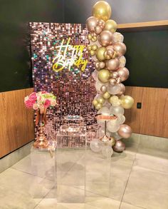 balloons and vases are on display in front of a happy birthday sign at a party