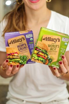 a woman holding two boxes of food in her hands