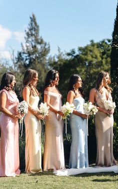 a group of women standing next to each other on top of a lush green field