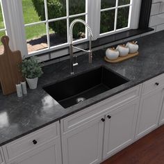 a black kitchen sink sitting under a window