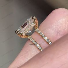 a woman's hand with an engagement and wedding ring set on top of her finger