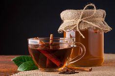 two mugs filled with tea and cinnamon sticks