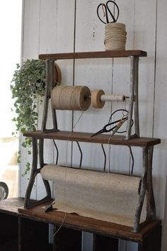 an old wooden shelf with some yarn and scissors on it