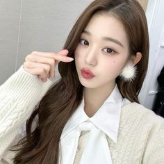 a woman with long brown hair wearing a white shirt and tie is posing for the camera