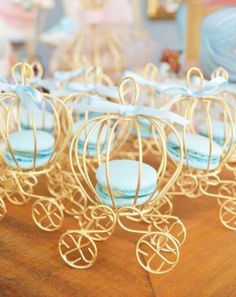 some little blue and gold toy carriages on a table