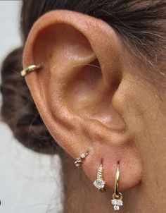 a close up of a person's ear with three small diamonds on it