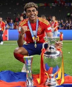 the soccer player is posing with his trophy