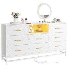 a white dresser with gold handles and drawers on the bottom, mirror above it that is lit up