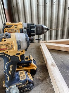 a cordless drill and two screwdrivers sitting next to each other