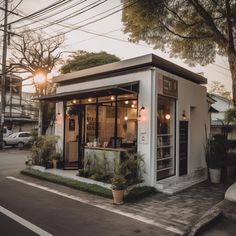 a small white building sitting on the side of a road next to a street light