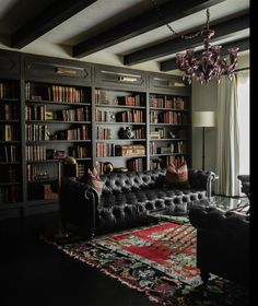 a living room filled with lots of furniture and bookshelves next to a window