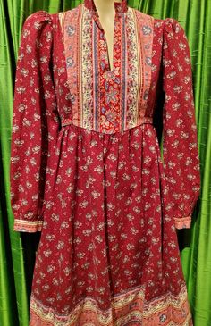 1970’s burgundy calico floral Gunne Sax style Cottage Core prairie cotton long sleeve dress.Can fit most sizes since it ties in the back, see photo of untied dress. Most dresses in this style are extra small, but not this one!PTP 39"High waist at seam 37" but can be tied as small as desired.Length 44"Very good condition. Retro Prairie Dress For Fall, Bohemian Floral Peasant Dress For Fall, Peasant Style Long Sleeve Fitted Dress, Peasant Long Sleeve Fitted Dress, Bohemian Floral Print Peasant Dress For Fall, Peasant Style Fitted Dress With Long Sleeves, Bohemian Long Sleeve Ditsy Floral Dress, Folk Style Long-sleeved Floral Print Dress, Folk Style Long Sleeve Floral Print Dress