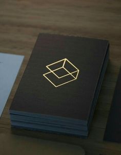 the business card is designed to look like a box with a golden logo on it