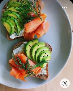 two slices of bread with salmon and avocado on them