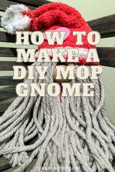 a red and white knitted santa hat sitting on top of a wooden bench with the words how to make a diy mop gnome