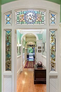 an entry way with stained glass and wood floors