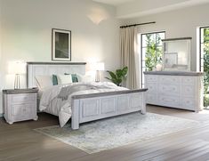 a bedroom with white furniture and wood floors