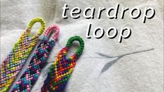 three different colored beaded items sitting on top of a white t - shirt that says teardrop loop