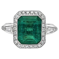 A stunning engagement ring, featuring a bezel-set 4.58 carats emerald cut green emerald. Surrounded by round brilliant cut diamonds in a halo design and features tapered baguette diamonds on both sides. Accent diamonds weigh 0.64 carat total. Elegantly finished with milgrain edges. Made with 18K white gold. Size 6.5 US, resizable upon request. Roman Malakov is a custom house, specializing in creating anything you can imagine. If you would like to receive a special quote on a custom piece, please Timeless Engagement Ring, Halo Design, Modern Engagement Rings, Stunning Engagement Ring, Dress Rings, Halo Diamond Ring, Engagement Ring Styles, Rings Jewelry, Halo Diamond Engagement Ring