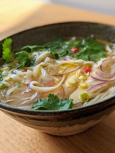 a bowl filled with soup sitting on top of a wooden table