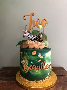 a green and gold cake with a zebra on top that says tuco beautien