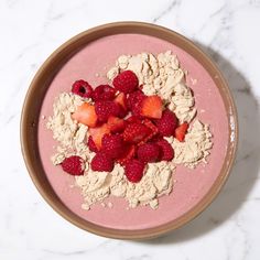 a bowl filled with oatmeal and strawberries on top of a table