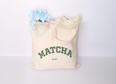 Grab your matcha tote bag on the go! Perfect tote bag when heading to your favorite coffee shop, running errands, or shopping at the farmer's market! Not your style? Take a look at our other tote bags: https://matchapandas.etsy.com/listing/1459602809 Dimensions: * One Size - 15" x 16" and with a handle length of 20" Materials:  * 100% cotton * Lightweight and compact  * Reinforced handle stitching  * Printed green MATCHA BABY text on tote bag Care Instructions:  * Remove all items inside bag. Mi Eco-friendly Green Bag With Letter Print, Eco-friendly Green Bags With Letter Print, Canvas Tote Bag Aesthetic, Cafe Hopping, Green Matcha, Baby Tote Bag, Aesthetic Tote Bag, Tote Bag Aesthetic, Bag Aesthetic