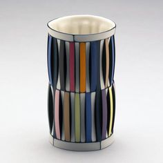 a multicolored glass vase is shown on a white surface with lines in it