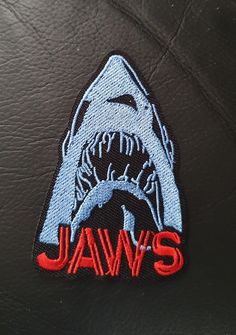 a close up of a patch on a leather jacket with a shark's head