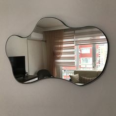 a mirror that is on the wall in front of a window